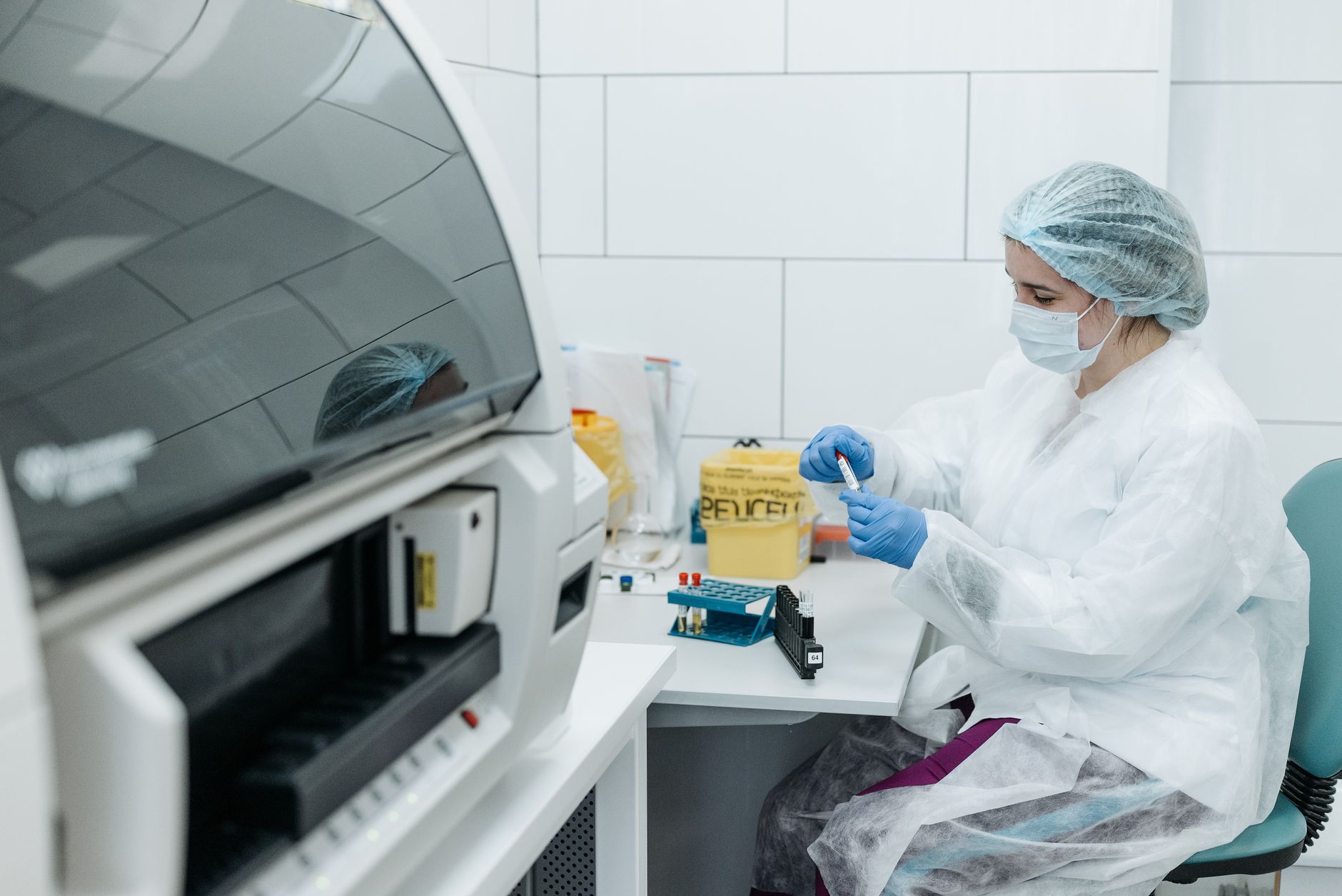 scientist working in laboratory with DNA strands and AI visualization, futuristic blue holographic displays, modern biotech facility with clean equipment