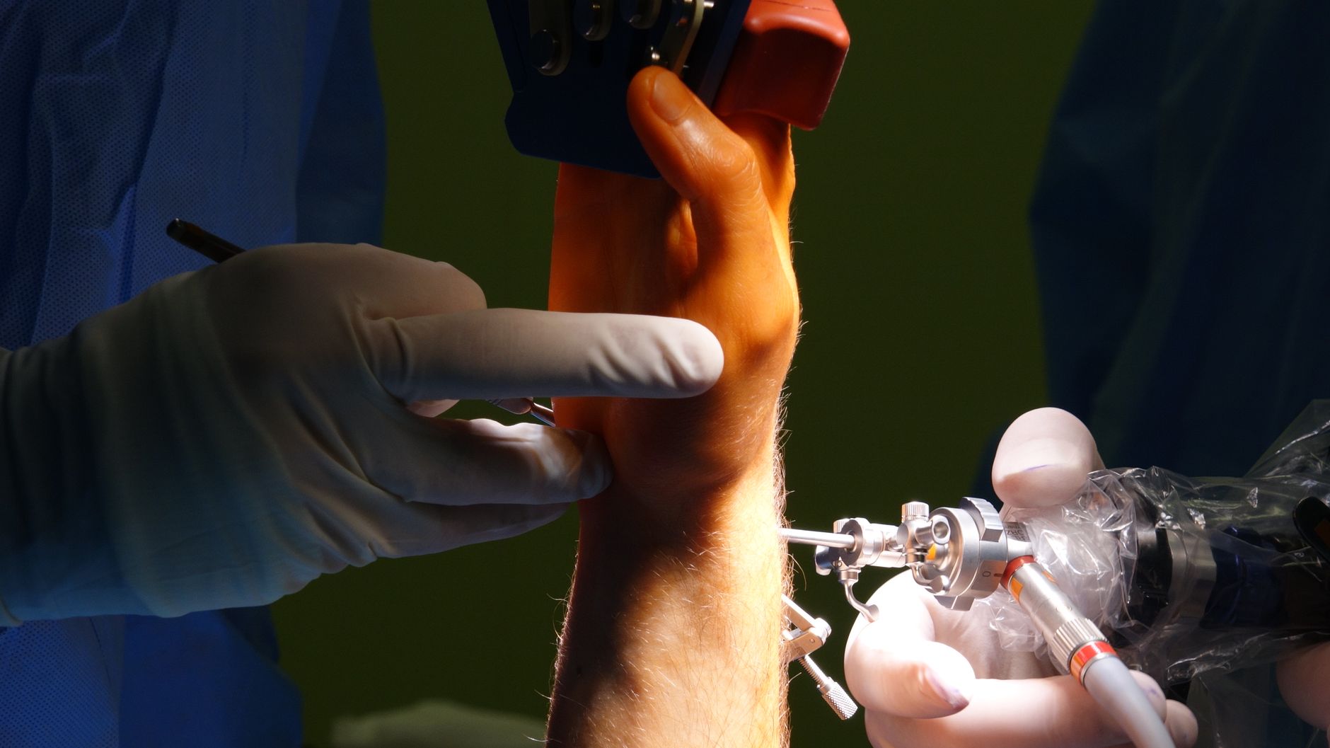 surgeon hands close up robotic surgical console hospital operating theater soft light