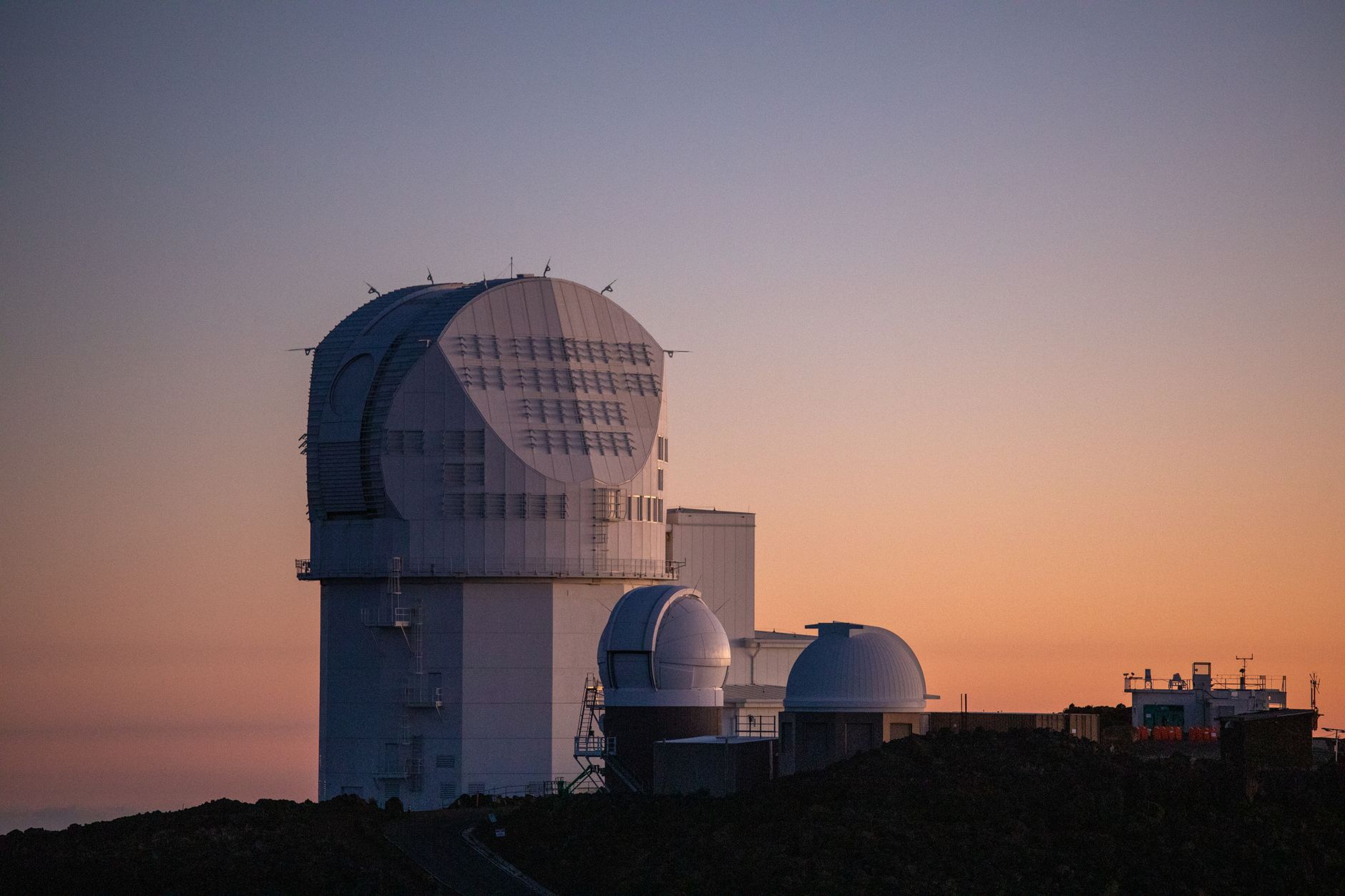 large solar telescope dome on volcanic mountain observatory at dusk, dramatic sky