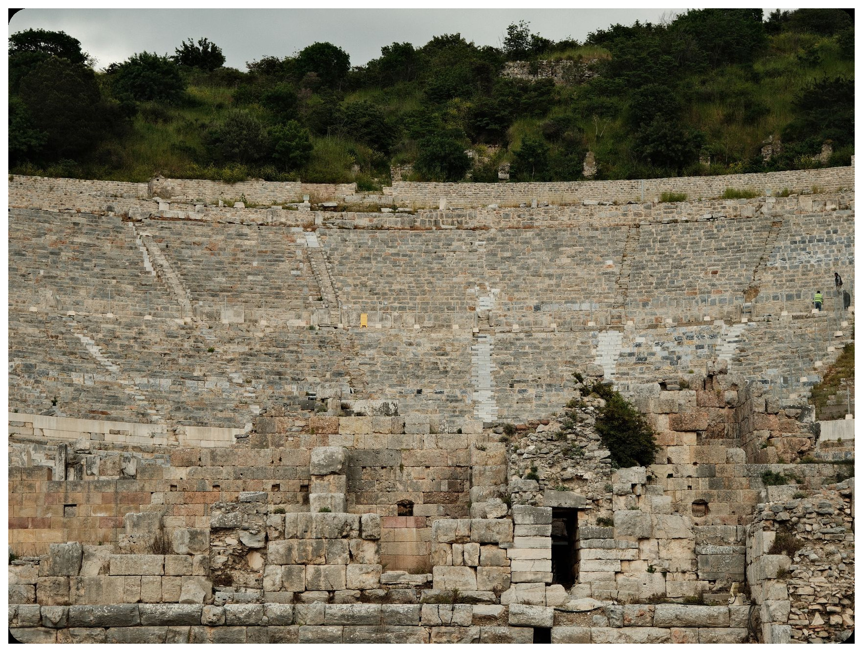 ruins of ancient roman circus theatre in toledo spain showing partially preserved stone walls and seating structures overgrown with vegetation afternoon sunlight