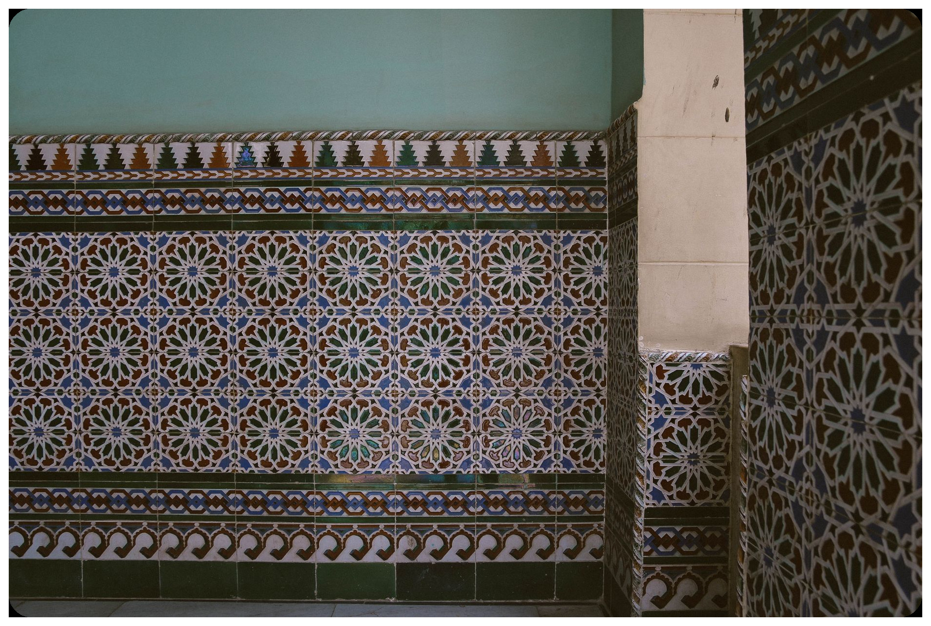 medieval Spanish kitchen reconstruction with clay pots and herbs hanging, warm firelight, Islamic geometric tilework on walls
