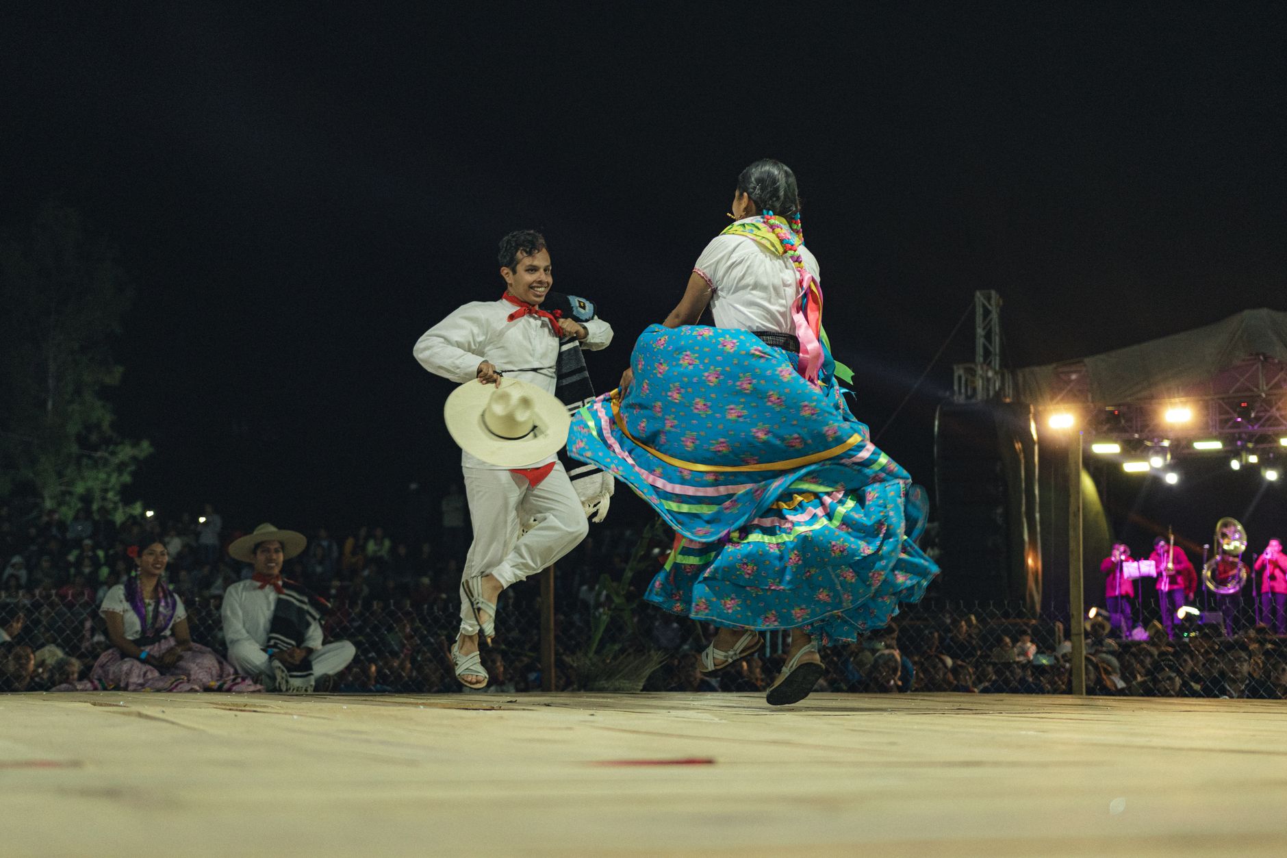 celtic dancers performing traditional steps stage lights energetic movement folk costumes string lights night festival