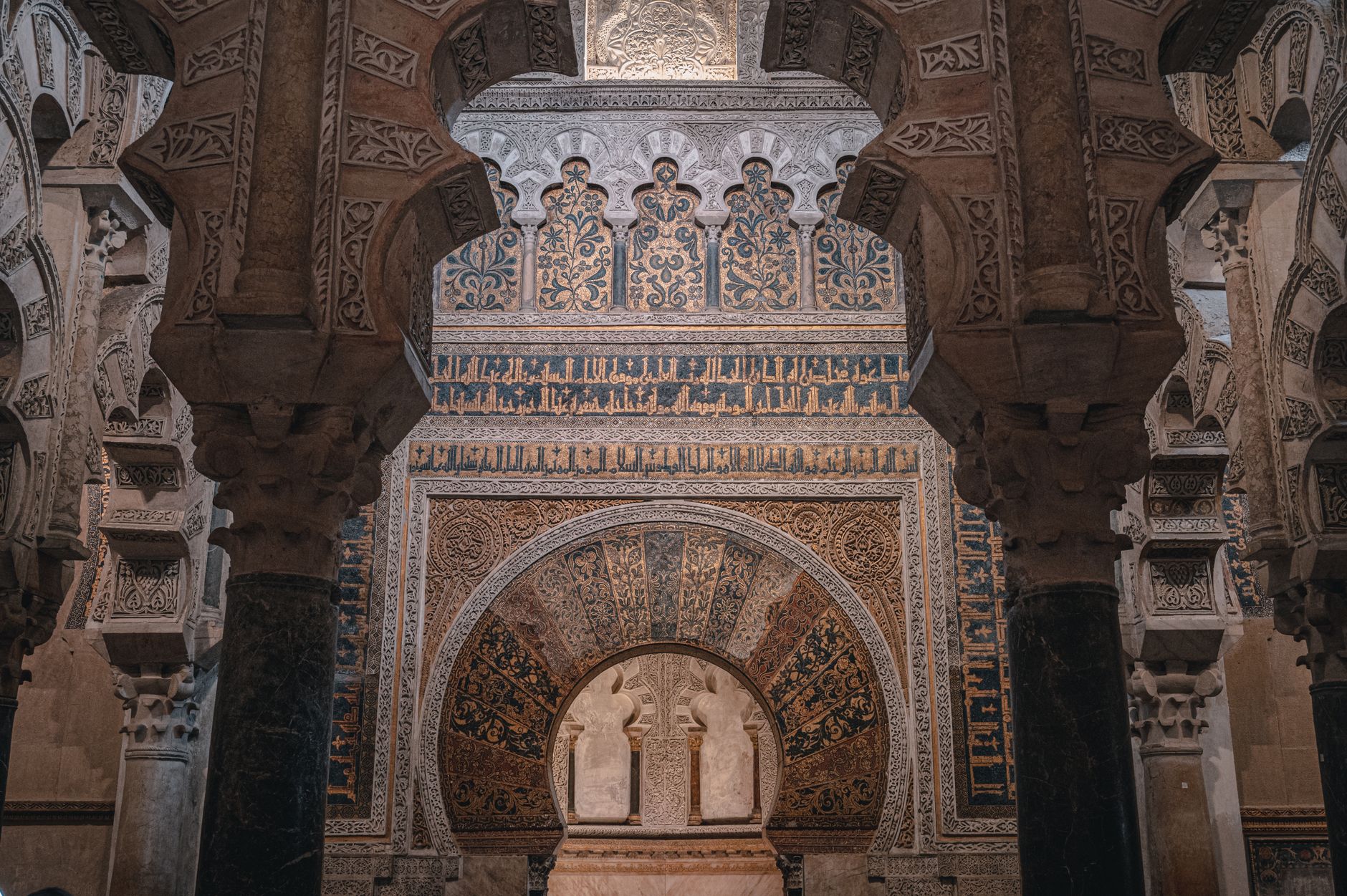ancient horseshoe arch stone doorway of Cordoba mosque cathedral dramatic afternoon light restoration scaffolding
