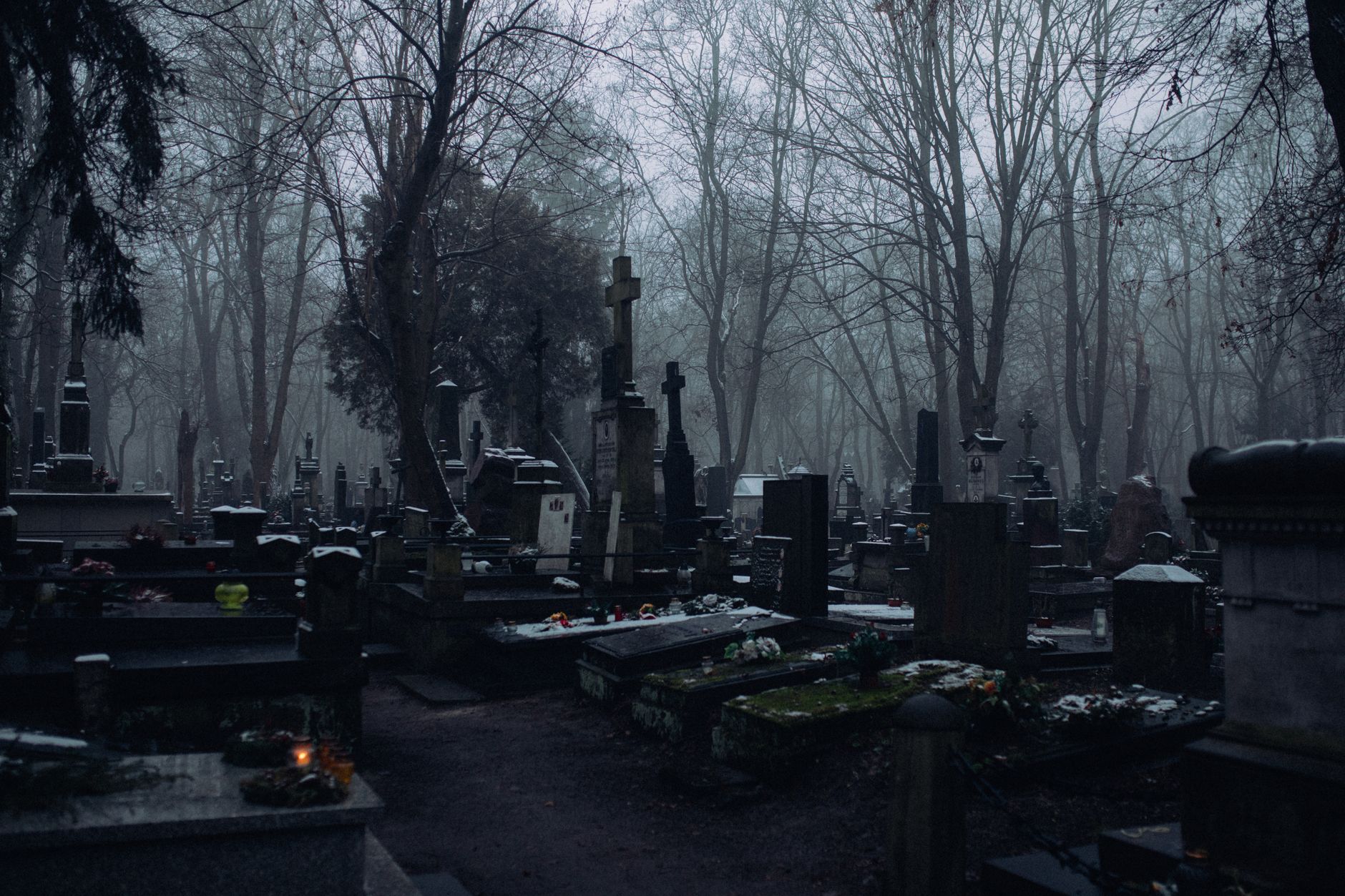 Medieval cemetery at twilight with Celtic crosses, fog rolling over gravestones, souls in white shrouds floating among tombs, mystical spiritual energy