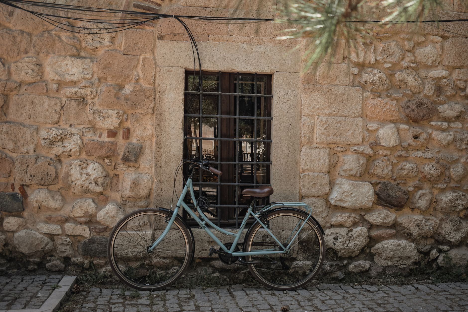 vintage painting leaning against a stone wall on an empty sunlit sevilla street