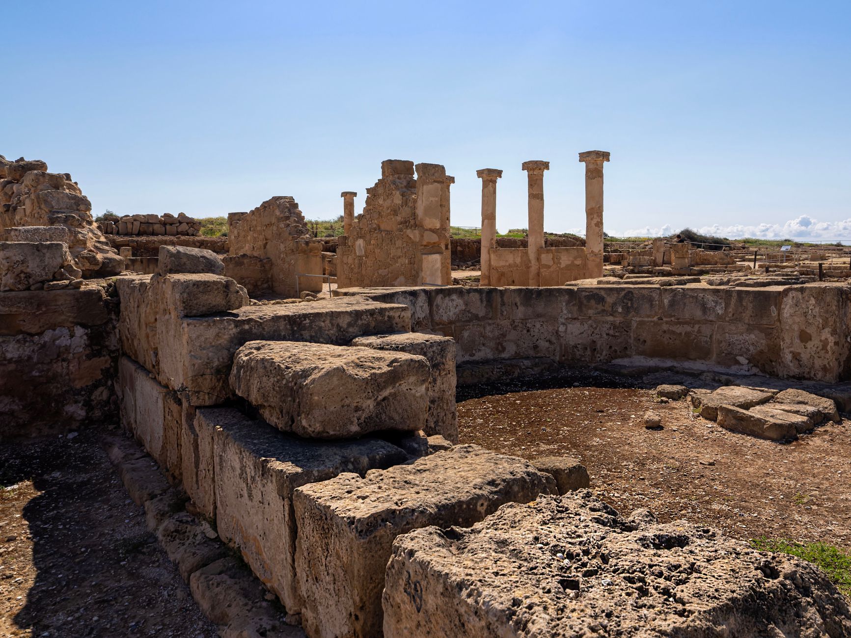 ancient roman road ruins with milestone and funerary monuments under golden sunlight, classical architecture stones weathered by time