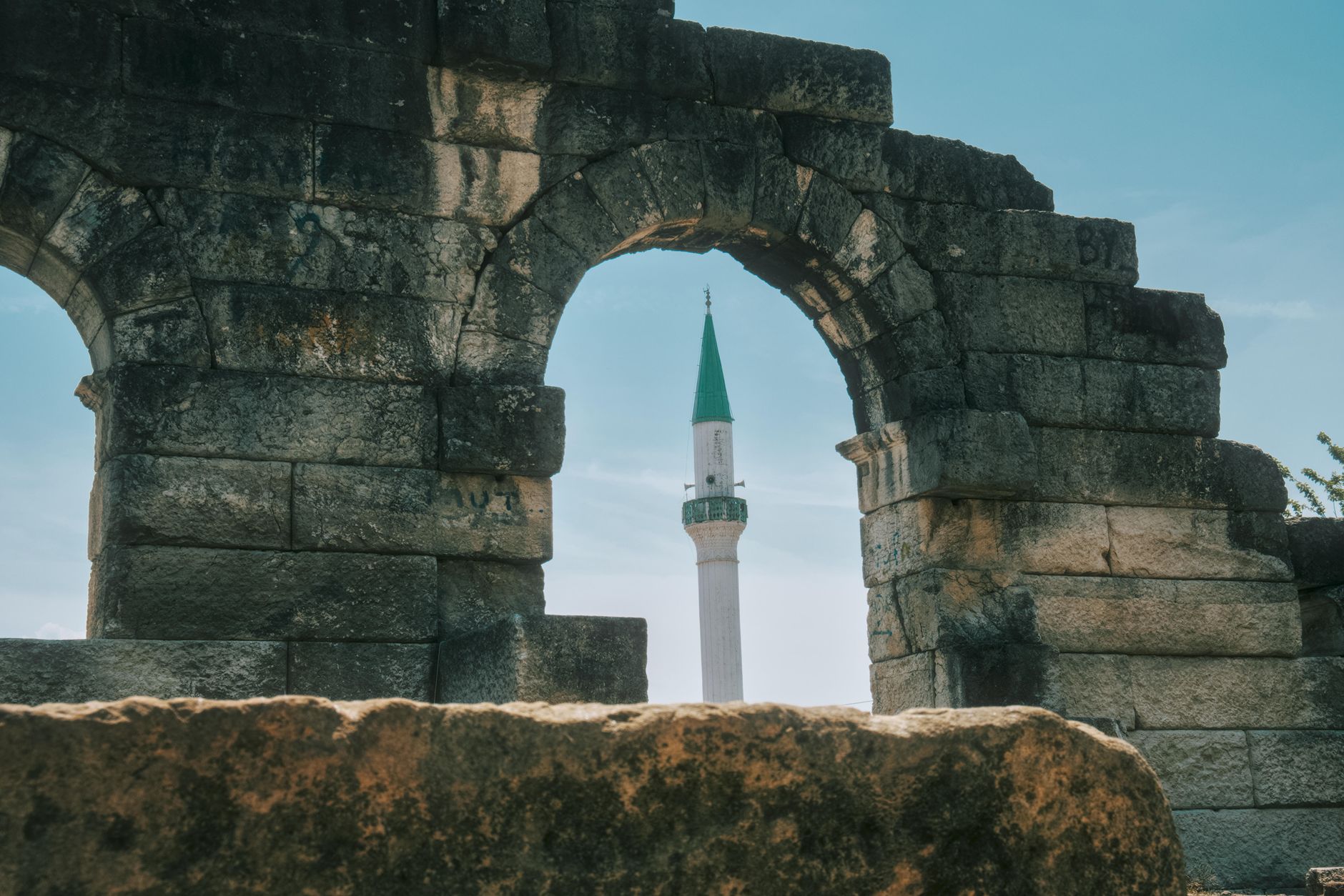 medieval islamic stone tower ruins integrated into modern building interior dramatic light