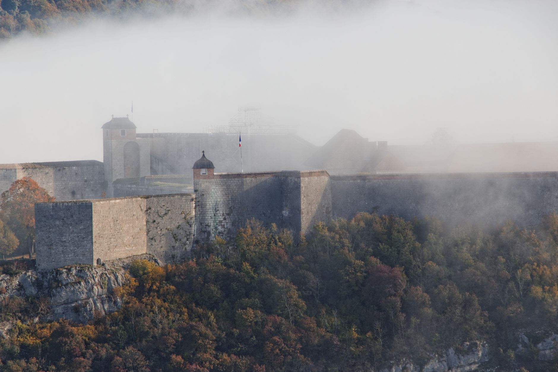 misty medieval fortress ruins on a hill overlooking a river border dramatic golden light